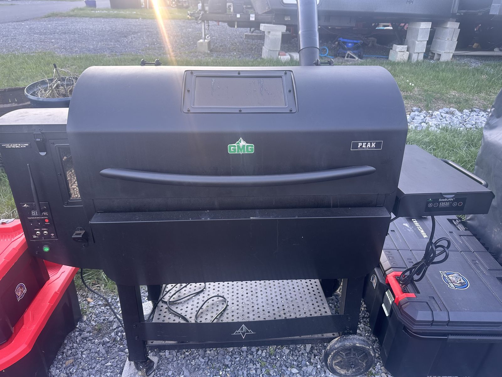 The black Green Mountain Grills Peak pellet grill with its window lid